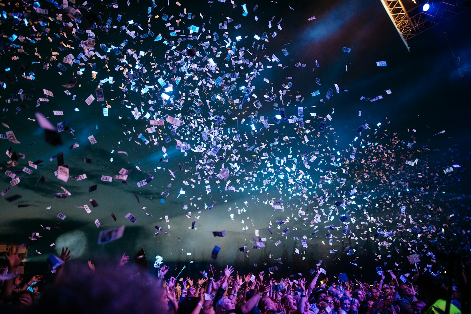 A crowd at a lively event holding up phones to take photos
