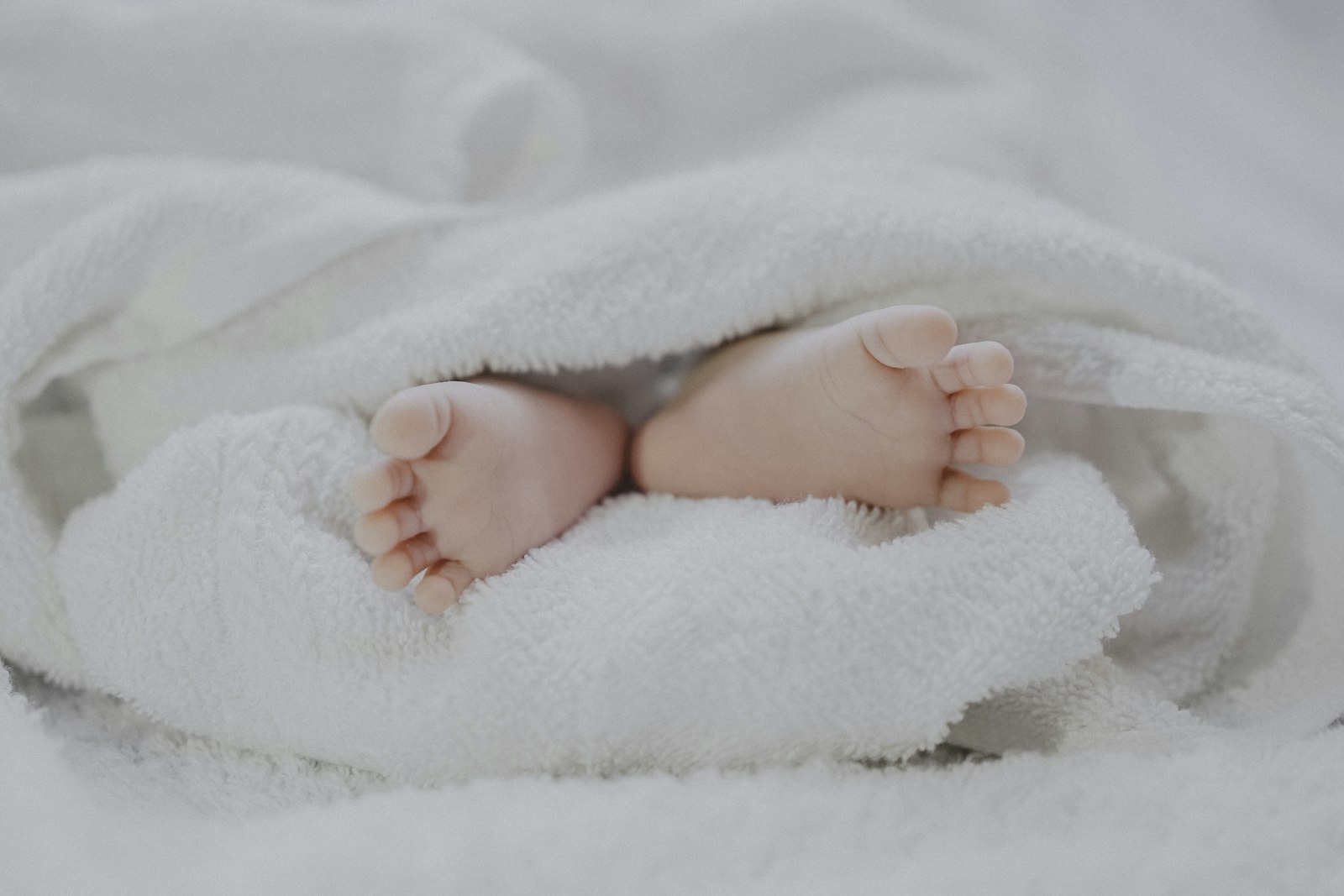 Tiny baby shoes resting on a soft blanket