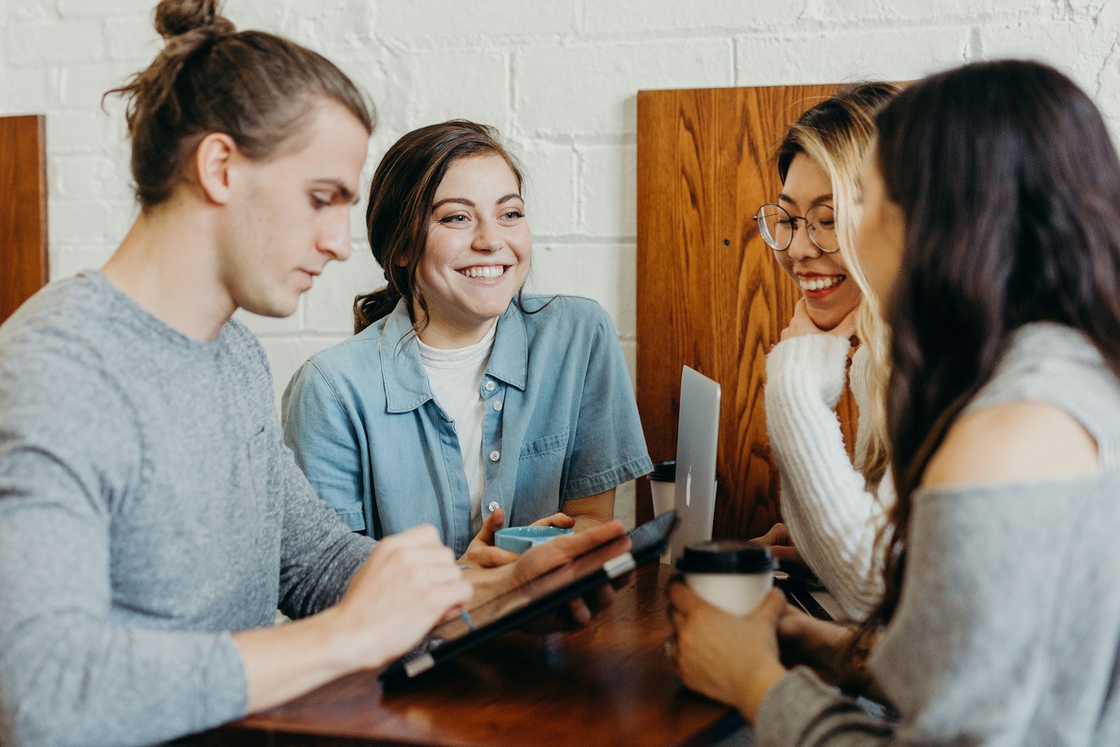 Friends laughing while looking at something on a phone together